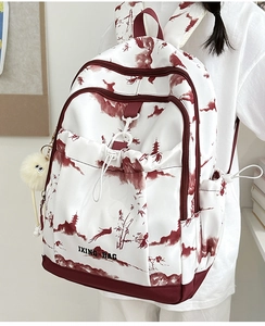 Détail d'un sac à dos blanc en toile avec imprimé montagne bordeaux et peluche