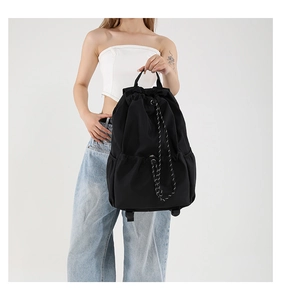 Detailed view of black nylon drawstring backpack showing large capacity and side pockets