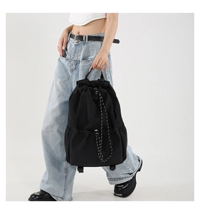 Detail of waterproof nylon drawstring backpack with front pocket and woven rope decor