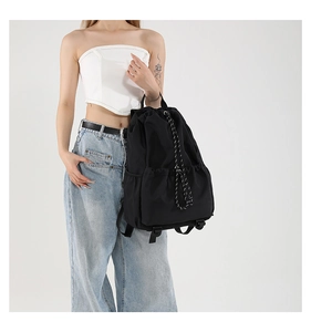 Detail of waterproof nylon drawstring backpack showing adjustable straps on model