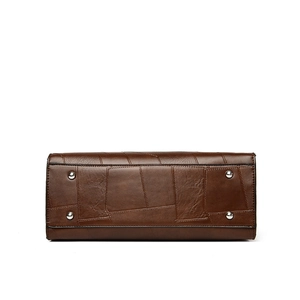 Bottom view of brown patchwork leather tote bag with four silver metal protective feet