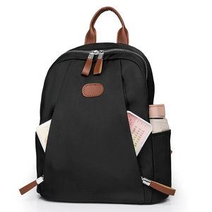 Minimalist black nylon backpack with brown leather details and multiple storage pockets