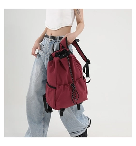 Detail view of burgundy waterproof nylon drawstring backpack with side elastic pockets