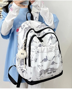 Détail du sac à dos avec imprimé lavis chinois et pendentif monstre en peluche sur mannequin