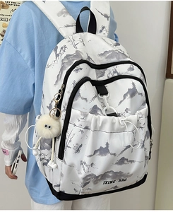 Détail d'un sac à dos blanc avec imprimé paysage chinois et charmant pompon blanc
