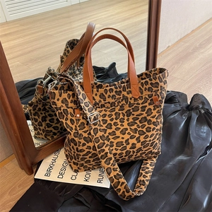 Large leopard print canvas tote bag with brown leather handles and wide shoulder strap