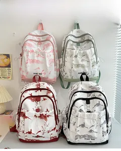 Vue détaillée de quatre sacs à dos à motif paysage en rose, vert, rouge et noir