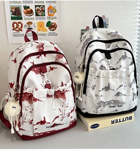 Détail de sacs à dos avec imprimés de paysages à l'encre et pendentif en peluche