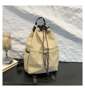 Detail of khaki waterproof nylon backpack with drawstring closure and large front pockets