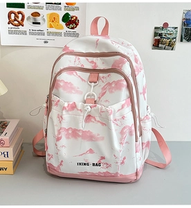 Détail de l'imprimé montagne rose sur sac à dos blanc avec poches latérales à cordon