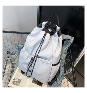 Detail of white nylon drawstring backpack with black buckle pocket in a metal basket