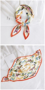 Detail of pleated silk scarf with butterfly print and orange edges on book