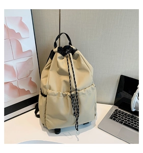 Detail view of khaki waterproof nylon drawstring backpack with side pockets and black straps