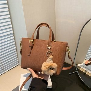 Chic brown litchi pattern bucket bag with a cute plush doll charm and gold hardware