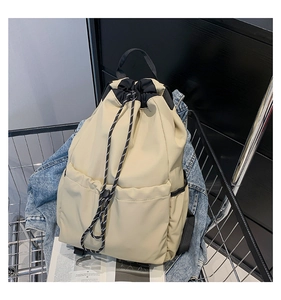 Detail of beige nylon drawstring backpack with side pockets placed in a shopping cart