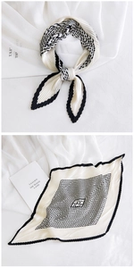Detail of pleated silk scarf featuring black and white geometric diamond pattern