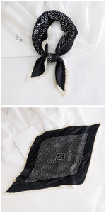 Detail of pleated silk scarf featuring black and white geometric polka dots and stripes