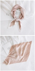Close-up of elegant pleated satin scarf with champagne gold gradient and texture