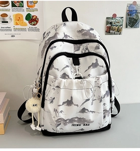 Détail d'un sac à dos style peinture chinoise avec charme en peluche et poches latérales