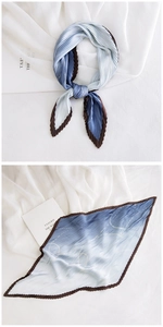 Detailed close-up of blue and brown pleated silk scarf with golden geometric lines