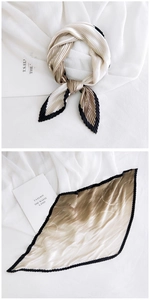 Detail showing gradient champagne pleated silk scarf with black wavy scalloped edges
