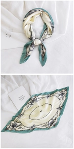 Close-up of pleated silk scarf with vintage chain patterns and green edges