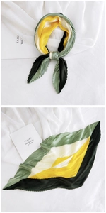Macro detail of pleated silk scarf with geometric color block and serrated edges