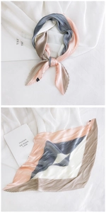 Detail of pleated square silk scarf with color-block design in pink, blue, and cream