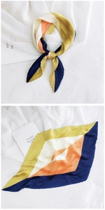 Detail of pleated silk scarf with orange and blue geometric color blocking style