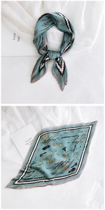 Detail of pleated silk scarf featuring retro geometric chain patterns in teal blue