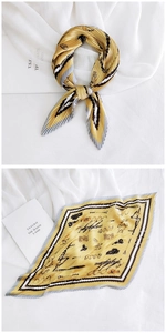 Detail of yellow pleated silk scarf with retro patterns and elegant folded texture