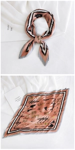 Detail of pink pleated silk scarf with equestrian horse bit pattern and geometric borders