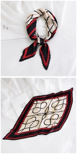 Detail of pleated silk scarf with red and black geometric patterns and edge borders