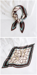 Detail of pleated silk scarf featuring blue and brown abstract patterns and wavy edges