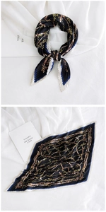 Detail of pleated silk scarf featuring vintage gold chain print and diamond shape design