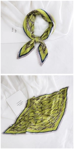 Macro detail of green pleated silk scarf featuring retro chain prints and contrast borders