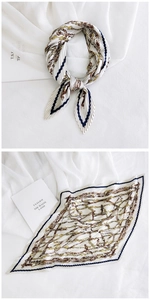 Detail of pleated silk scarf featuring retro chain print and navy blue borders in a bow