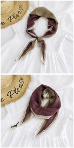 Detail of red and khaki cotton linen scarf with delicate cream lace floral trim