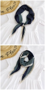 Detail of blue and green patchwork scarf with delicate white lace trim on the edges