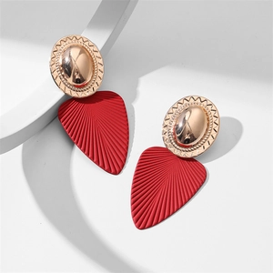 Détail de boucles d'oreilles feuilles rouges avec accents en métal doré texturé