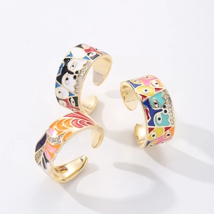 Detail of adjustable 18K gold rings with enamel flower, evil eye and zircon inlay