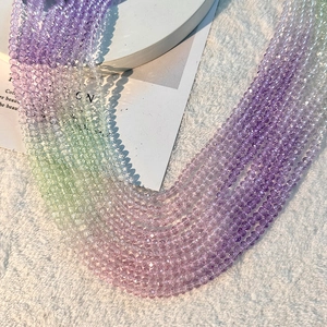 Détail macro de perles en cristal facetté avec dégradé violet et rose sur fourrure blanche