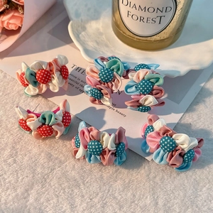 Vue à plat de boucles d'oreilles fleurs en tissu faites main avec détails à pois