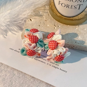 Détail de boucles d'oreilles fleurs en tissu faites main avec boutons à pois sur plateau