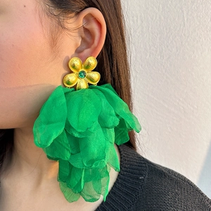 Close-up of handmade green flower tassel earrings with layered fabric petals and gold details