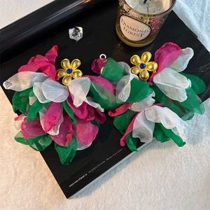 Detailed macro view of handmade layered chiffon flower earrings with golden core details