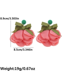 Detailed view of large pink fabric flower earrings with green ribbon bow and size metrics