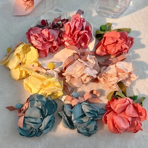 Macro shot of colorful fabric flower hair clips with satin bows on white fur surface
