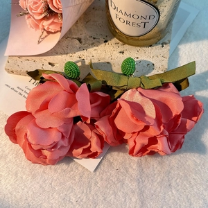 Detail of pink satin flower earrings with green silk bows and beaded floral centers