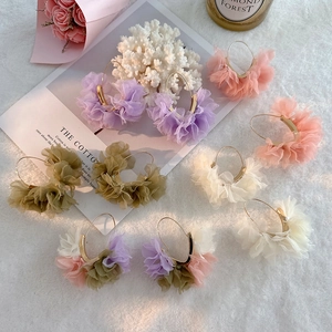 Detailaufnahme von V-förmigen Goldreifen mit bunten Organza-Netzblumen und Rüschen